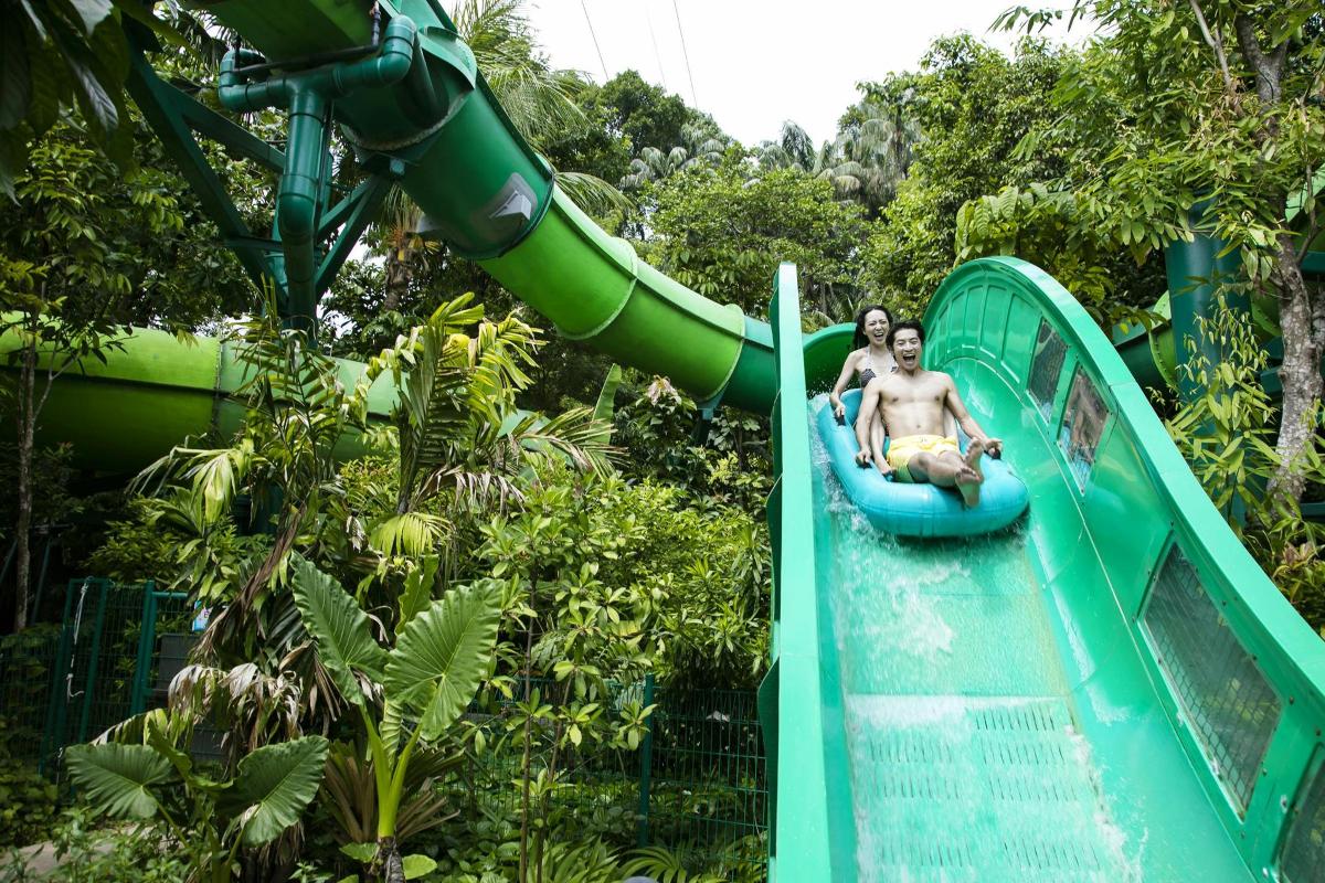 two people riding a water slide at a theme park