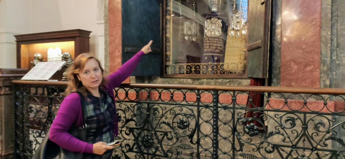 μια γυναίκα που στέκεται δίπλα σε έναν σιδερένιο φράχτη
