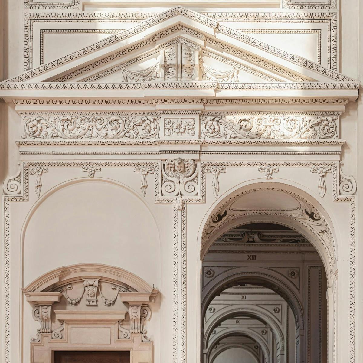 an ornate white room with two archways