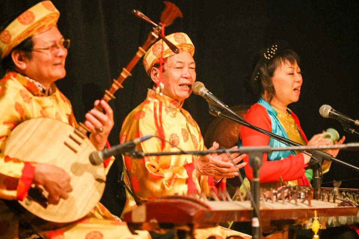 a group of three people playing instruments on a stage