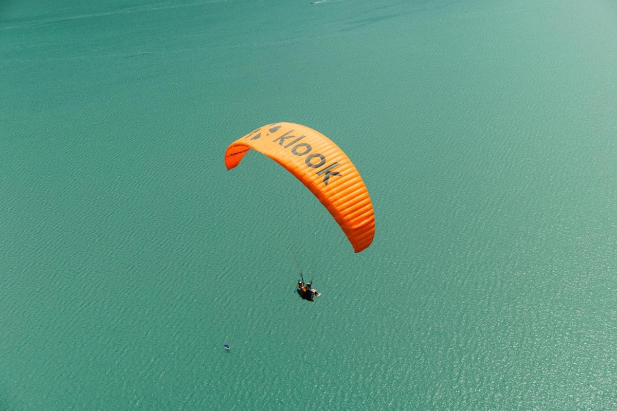 a person riding a kite in the air over the water