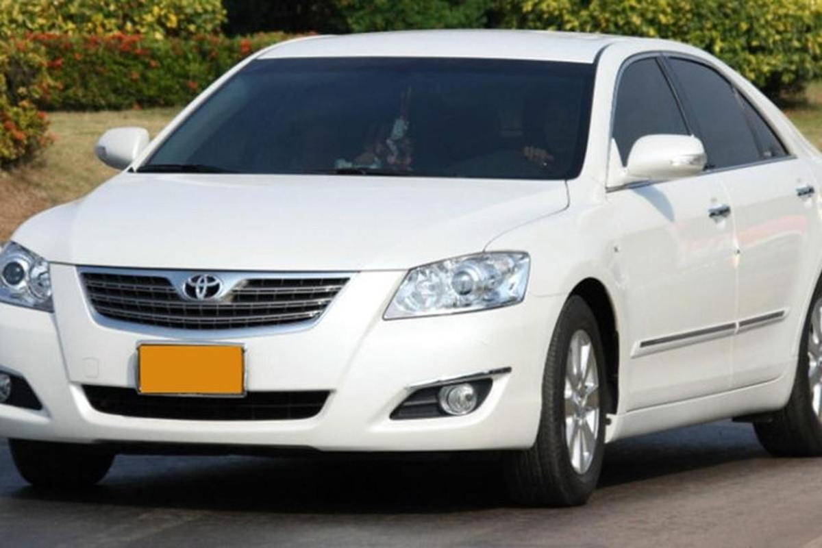 Білий автомобіль Hyundai Genesis, припаркований на під'їзній доріжці