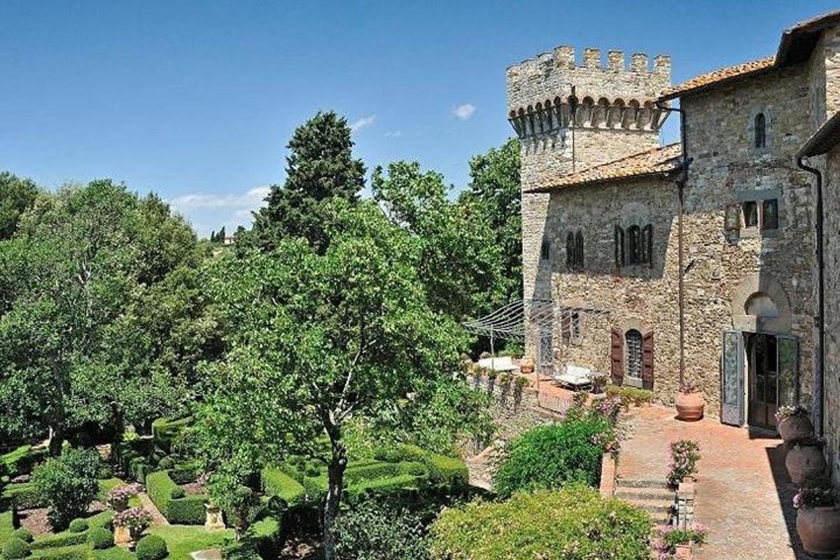 un vecchio edificio in pietra con un giardino antistante