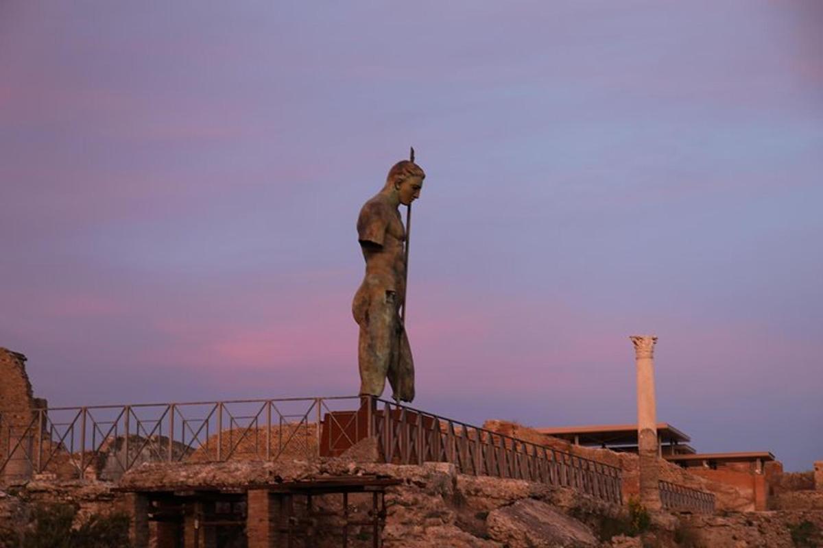 ένα άγαλμα ενός άνδρα στην κορυφή ενός κτιρίου