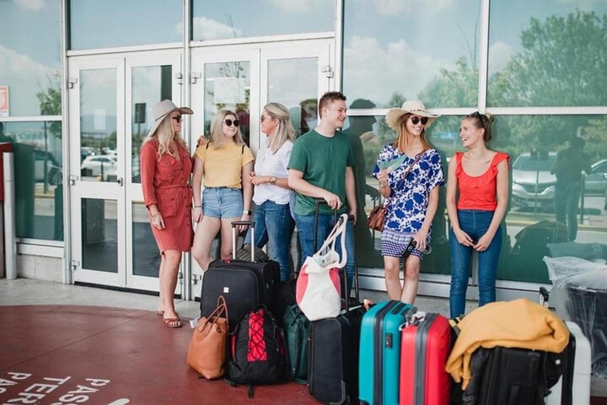 skupina ljudi, ki stojijo na letališču s prtljago
