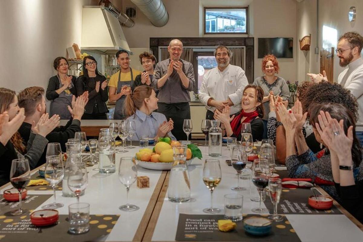 skupina lidí sedících kolem stolu a mávajících