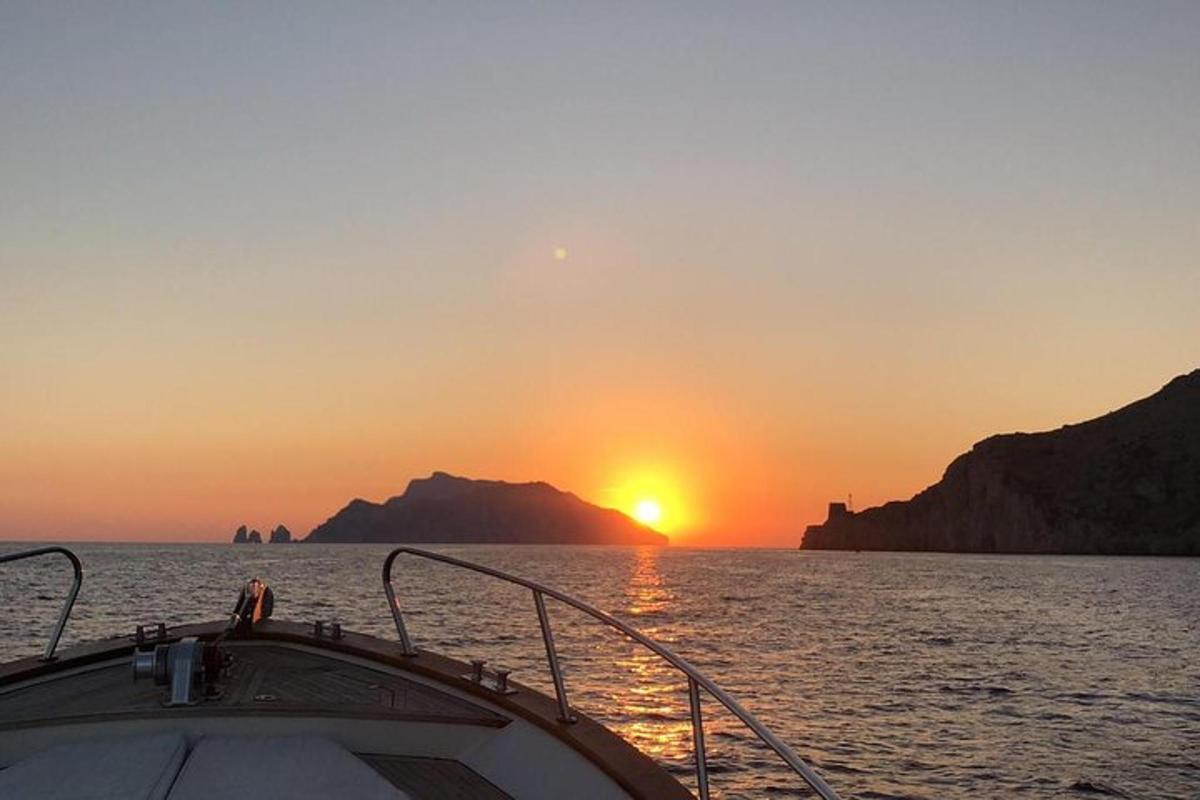 Un barco en el agua con la puesta de sol de fondo