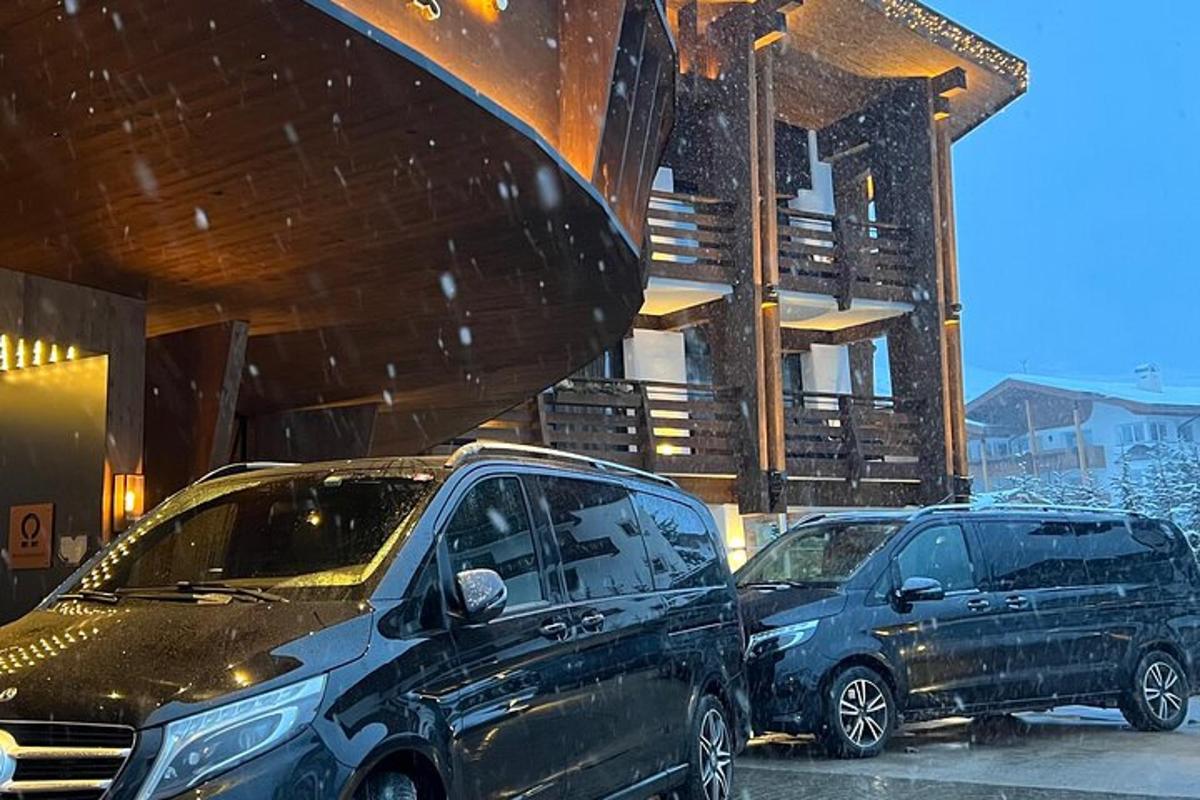 Dos coches aparcados delante de un edificio en la nieve.