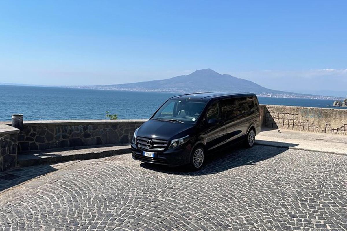 un furgone nero parcheggiato su una strada vicino all'oceano