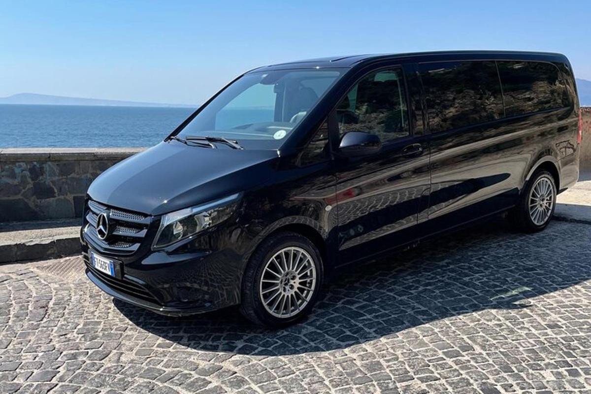 un furgone nero parcheggiato su una strada lastricata vicino all'oceano