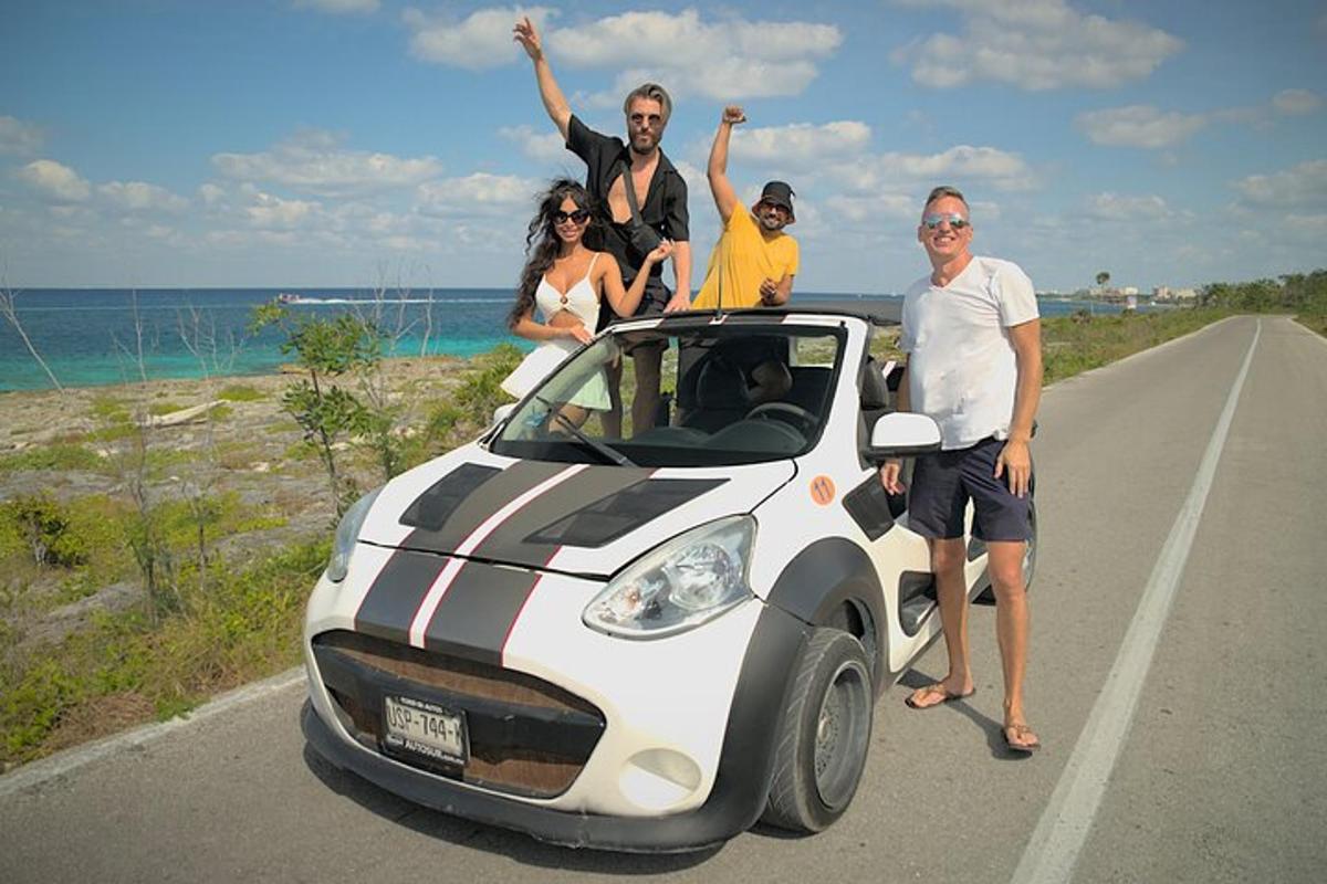 grupp inimesi istub väikese auto katusel