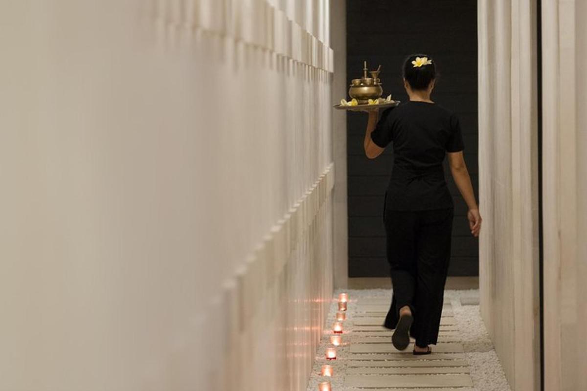 seorang wanita berjalan menyusuri lorong sambil membawa sepiring makanan