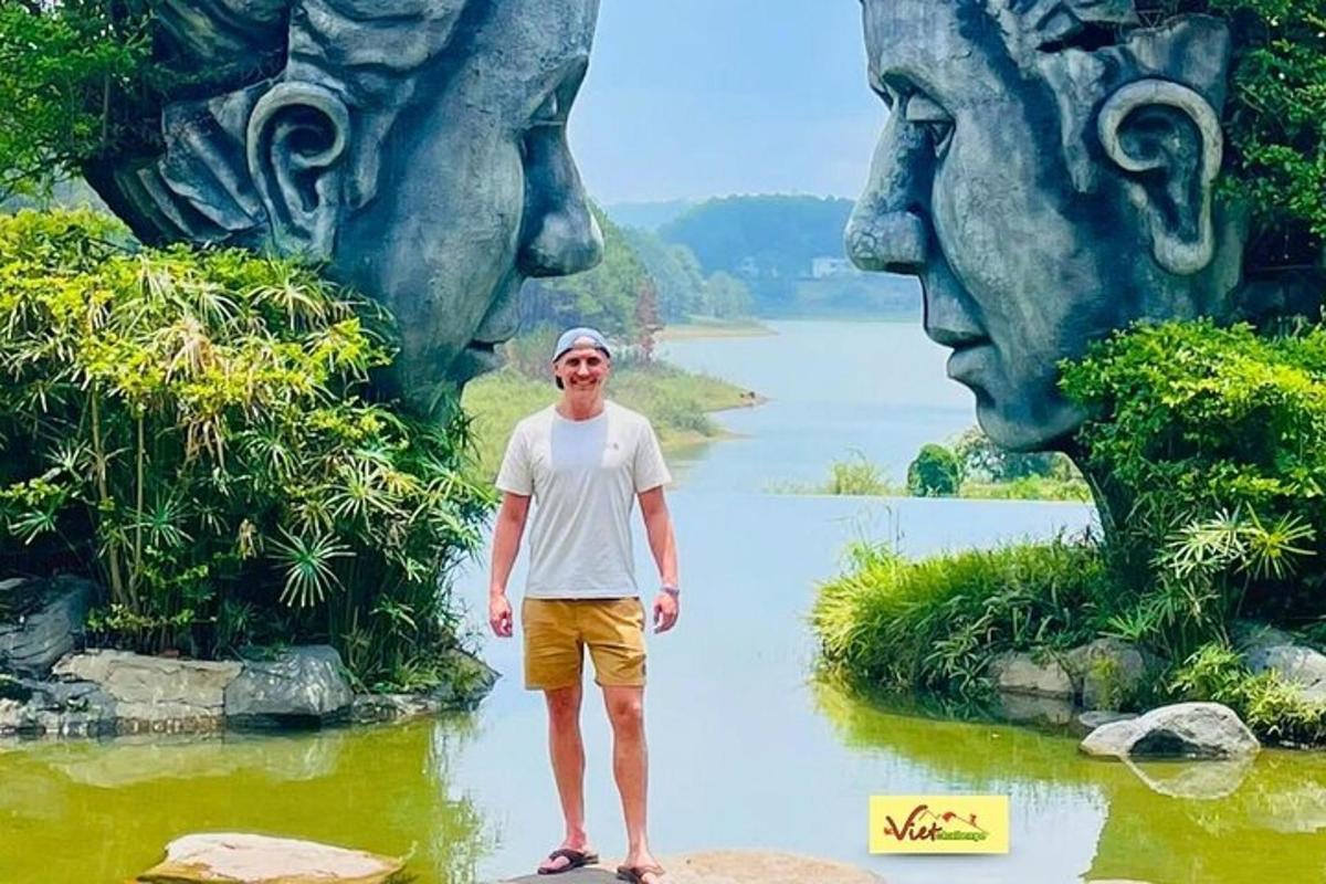 a man standing in front of a painting of faces
