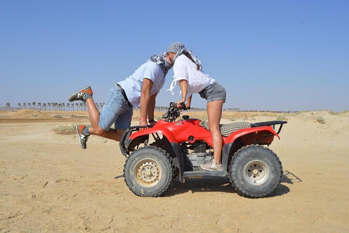 due persone su un quad sulla spiaggia
