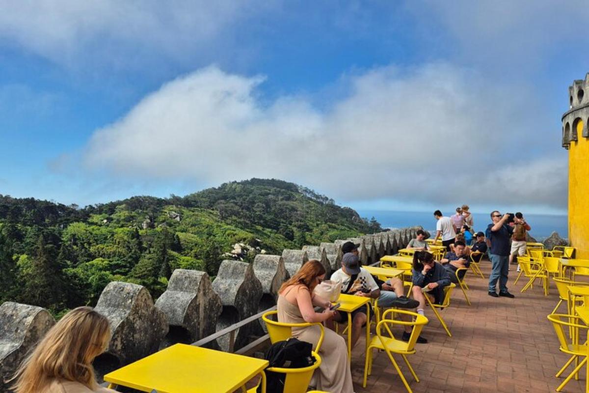 a group of people sitting at tables on top of a building