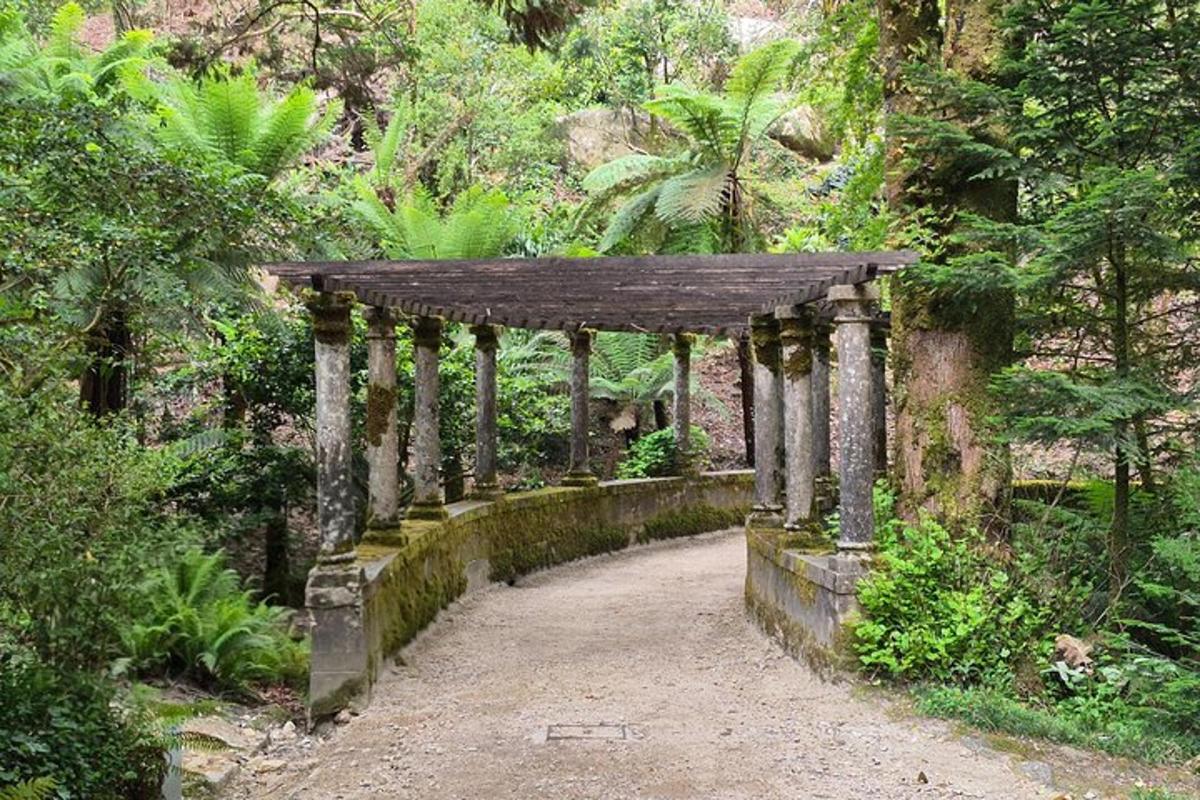 a stone archway in the middle of a garden