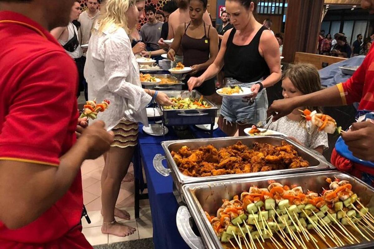 un gruppo di persone in piedi attorno a un buffet di cibo