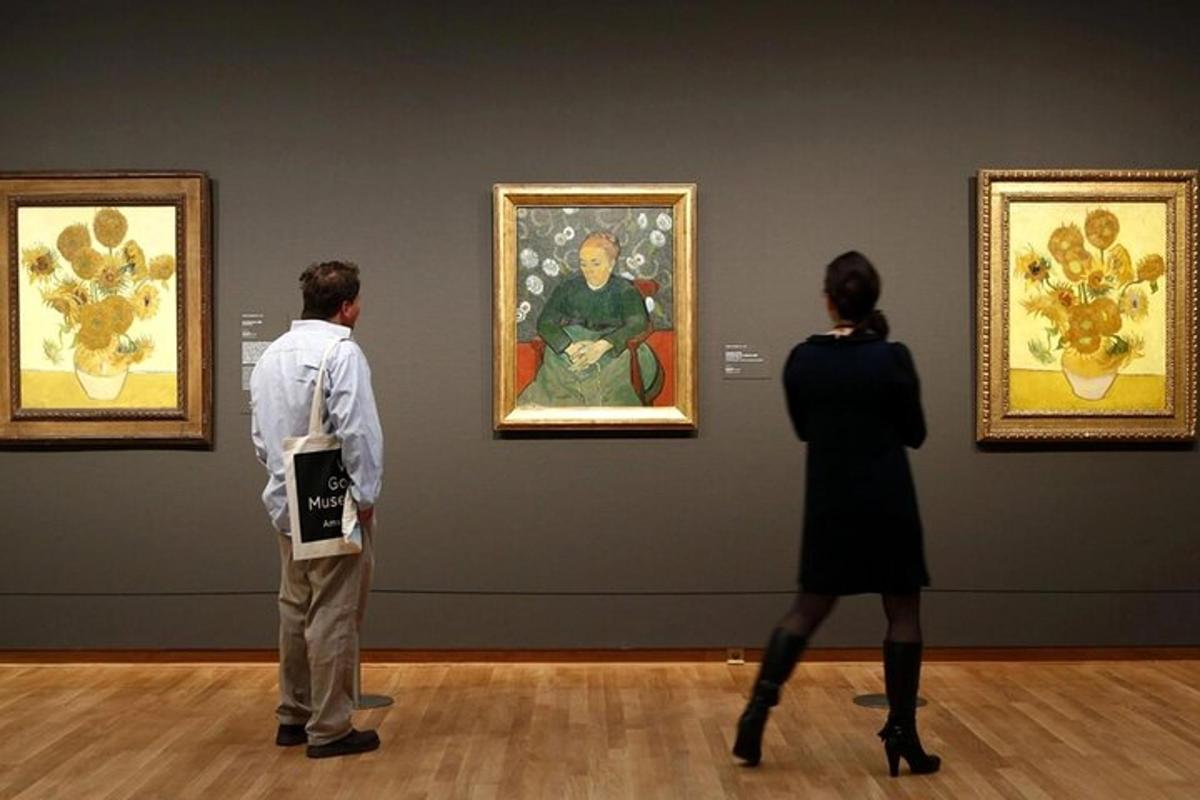 two people looking at a painting in a museum