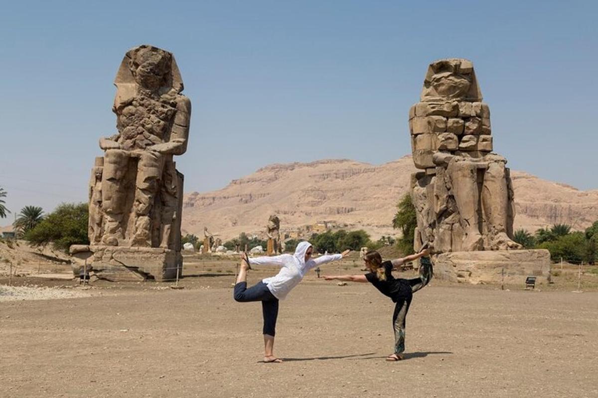 dua orang melakukan yoga di hadapan monumen