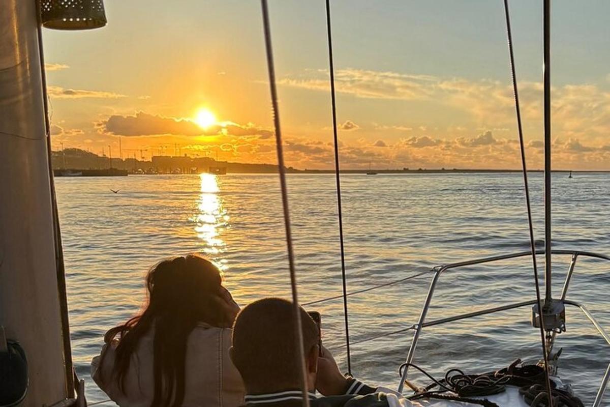 a man and woman sitting on a boat watching the sunset