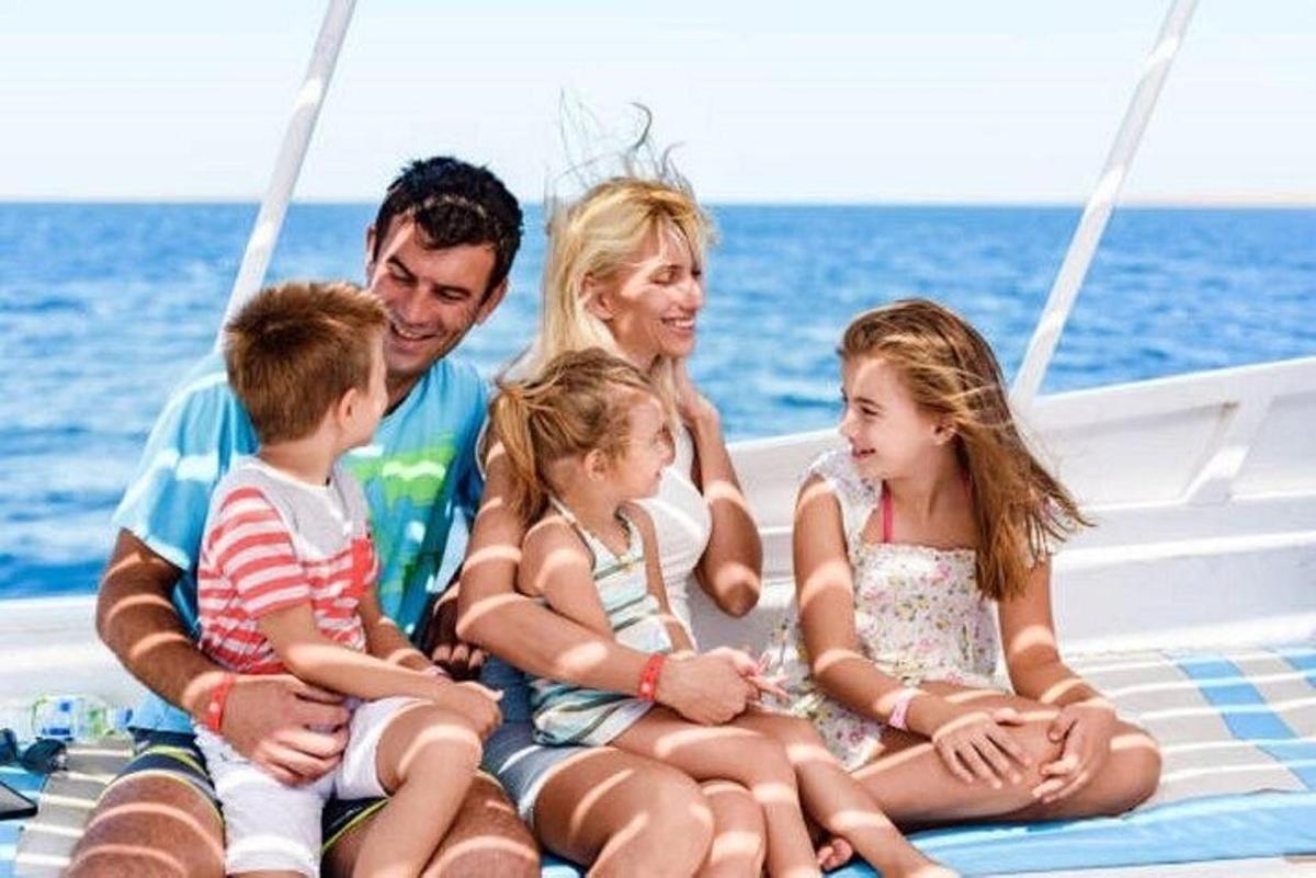 bir teknenin arkasında oturan bir aile