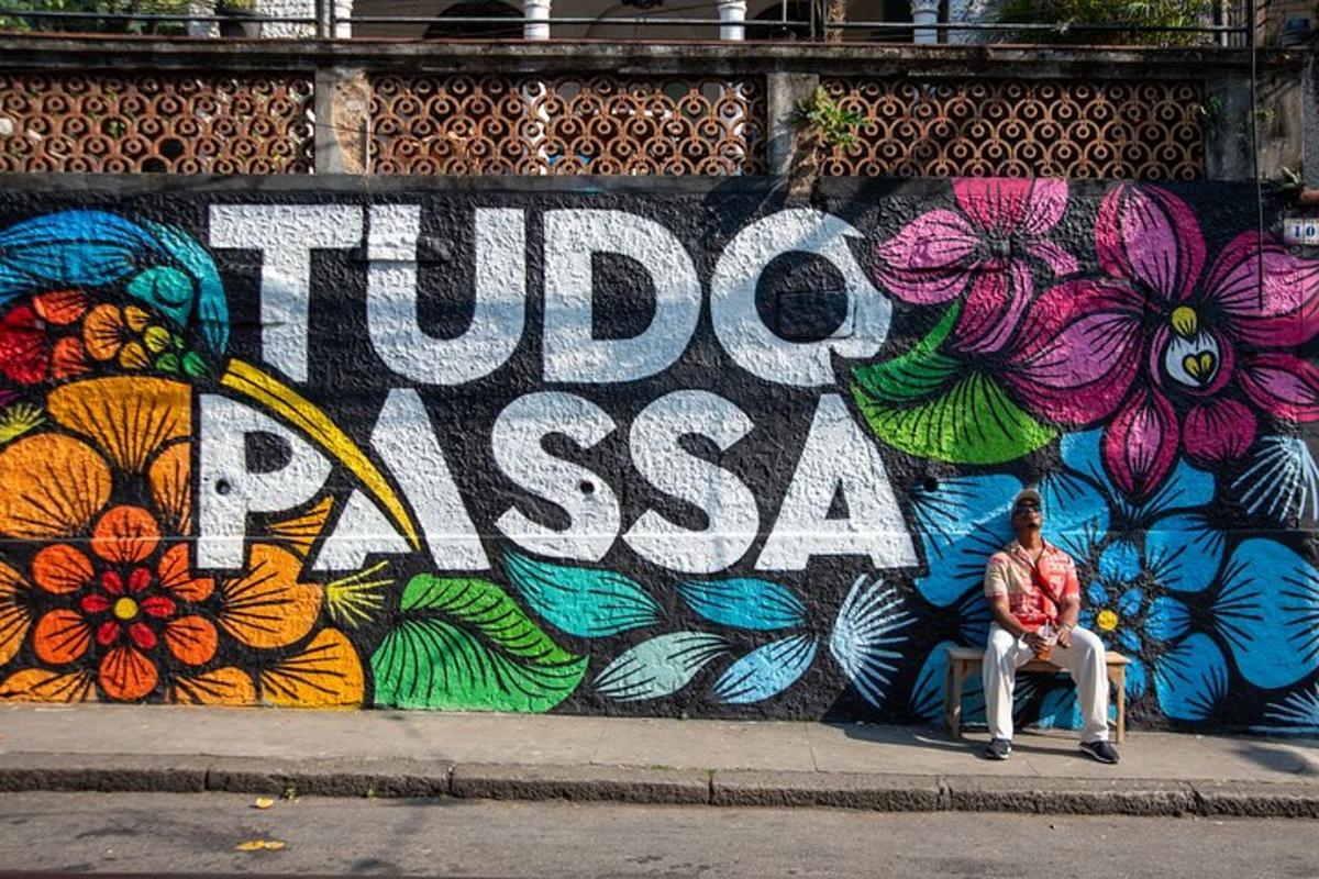 seorang pria duduk di depan dinding dengan mural