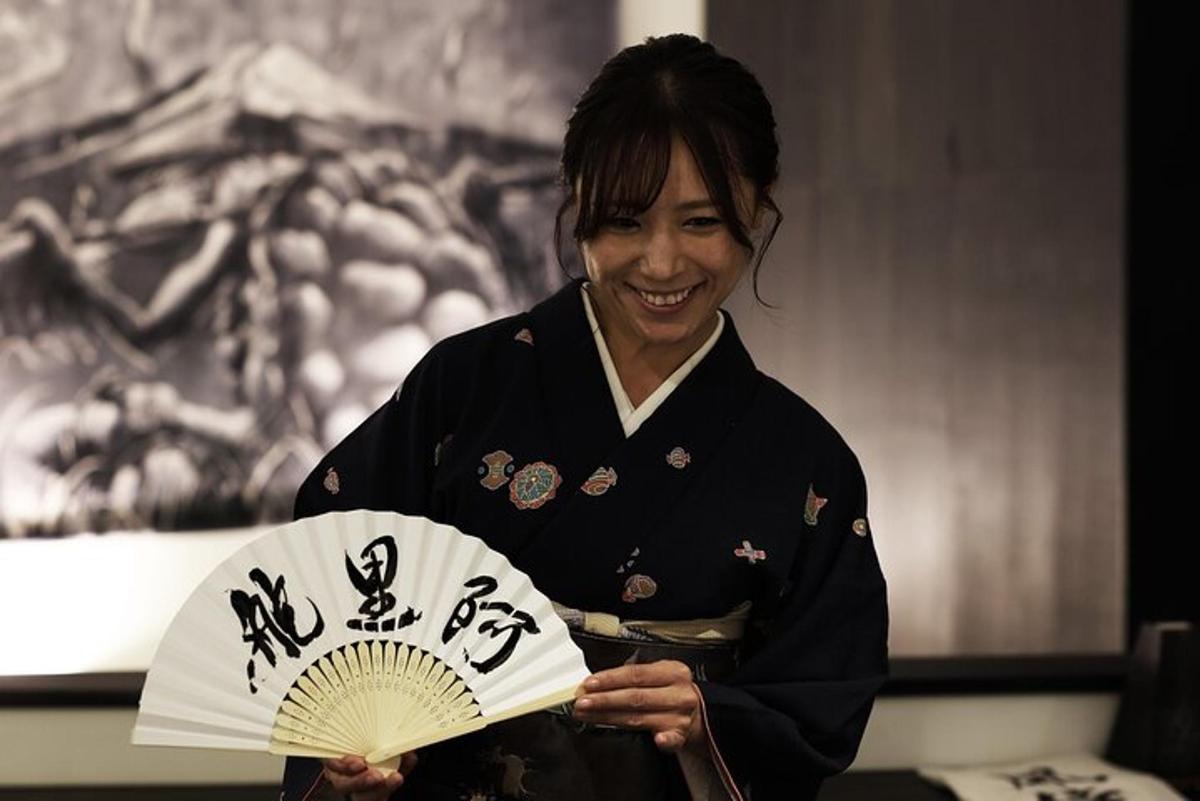 una donna in kimono che tiene in mano un ventaglio