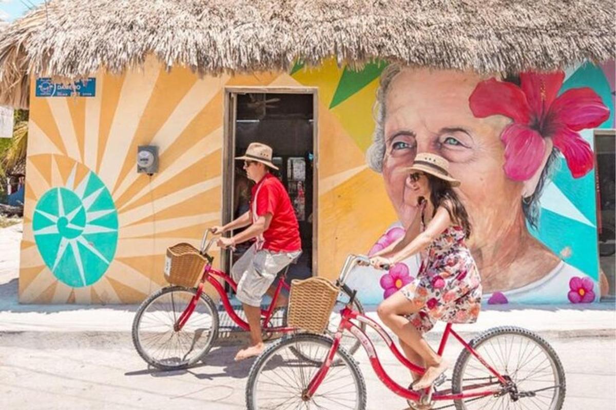 a man and a girl riding bikes in front of a mural