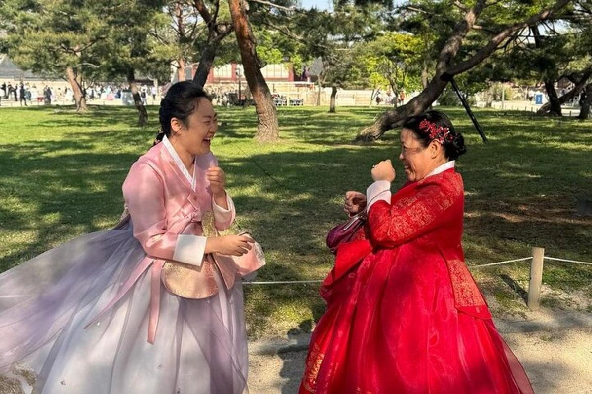 two women in dresses walking in a park