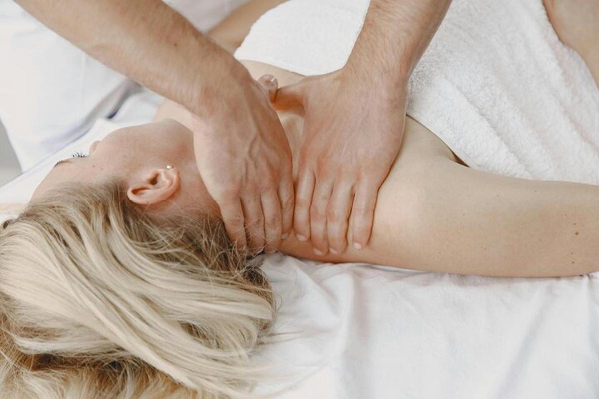 a woman laying on a bed with her hands on her back