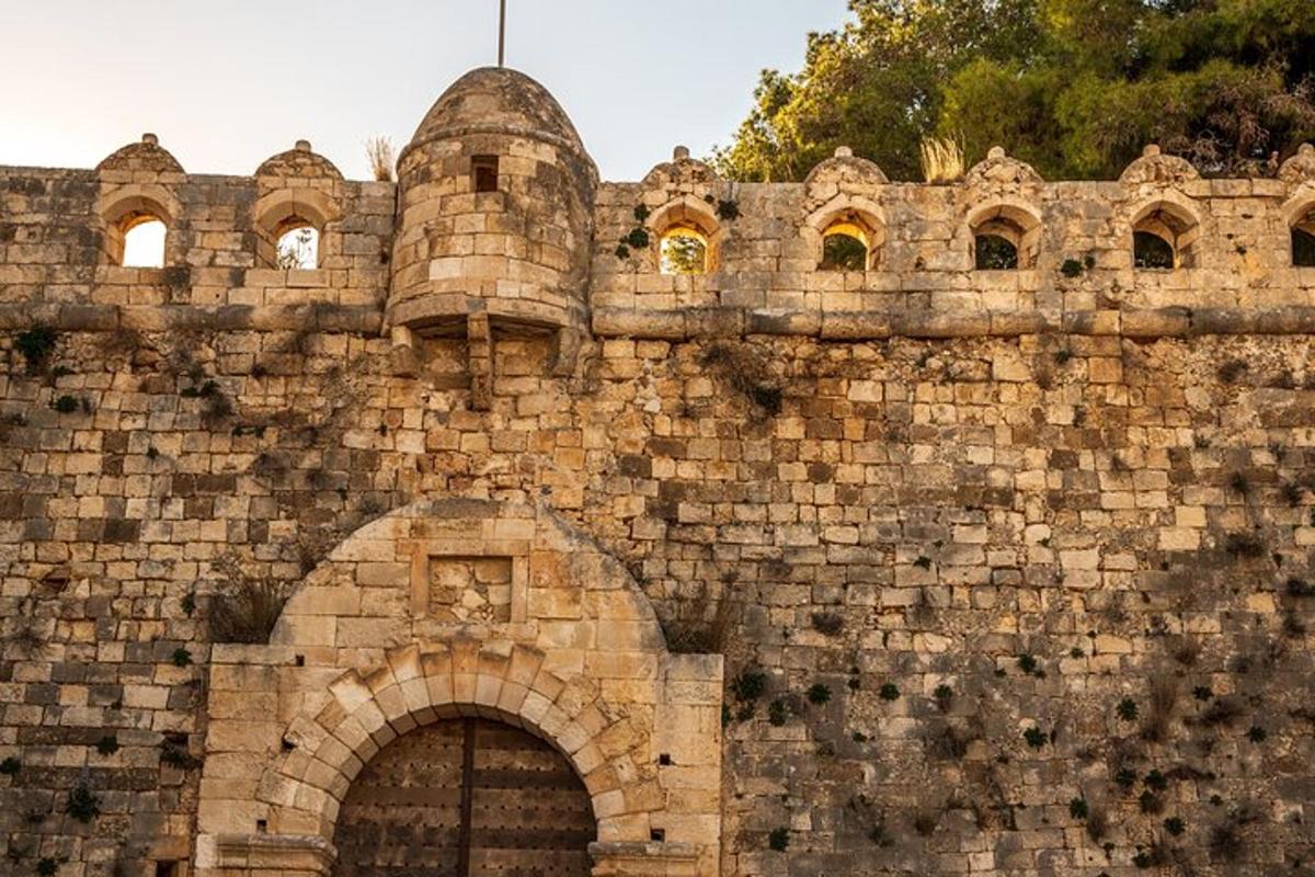 una antiga paret de maons amb una porta i un edifici