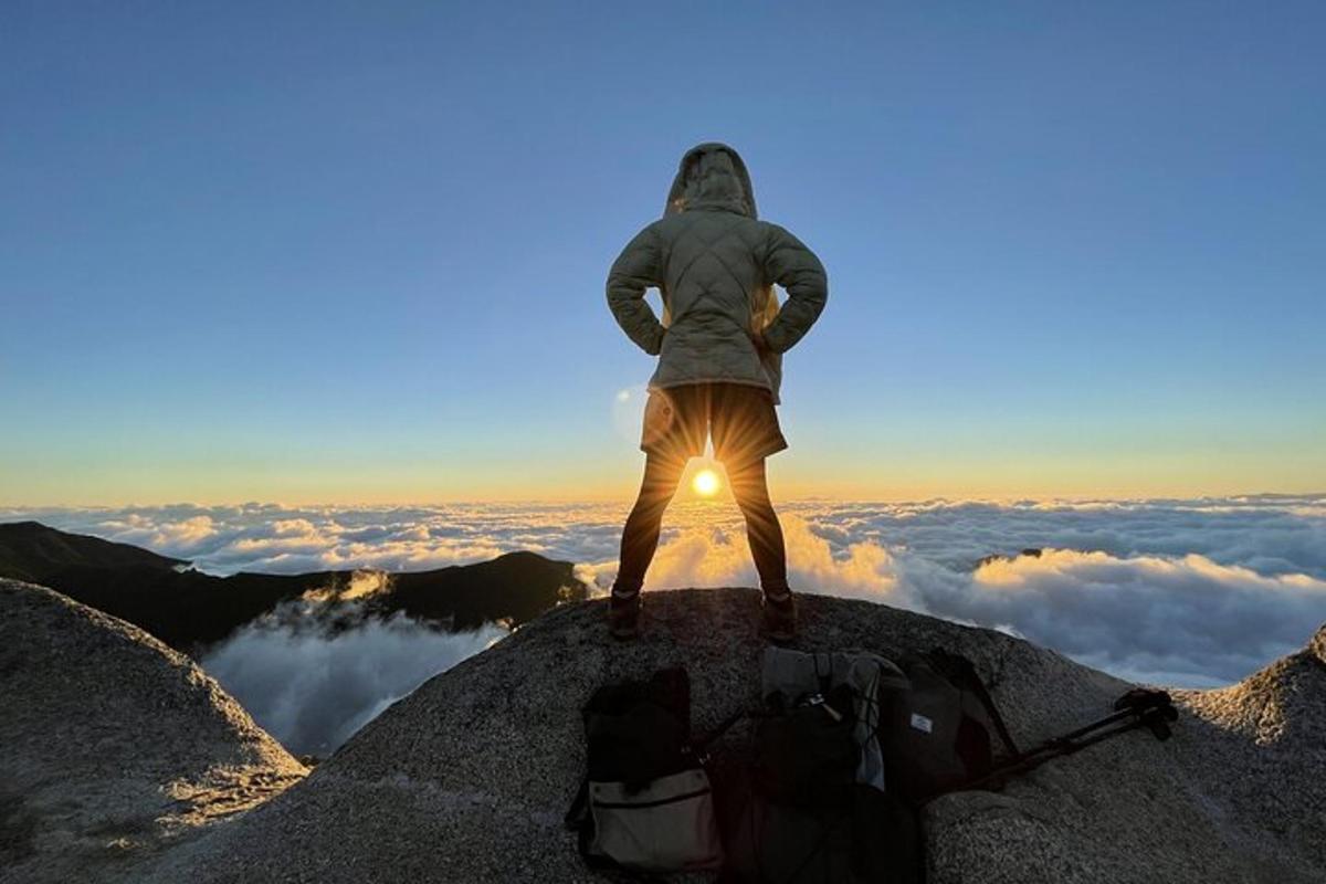 en mann som står på toppen av et fjell