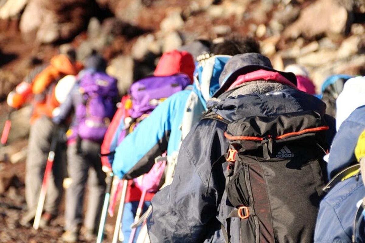 isang grupo ng mga taong naglalakad sa isang bundok na may mga backpack