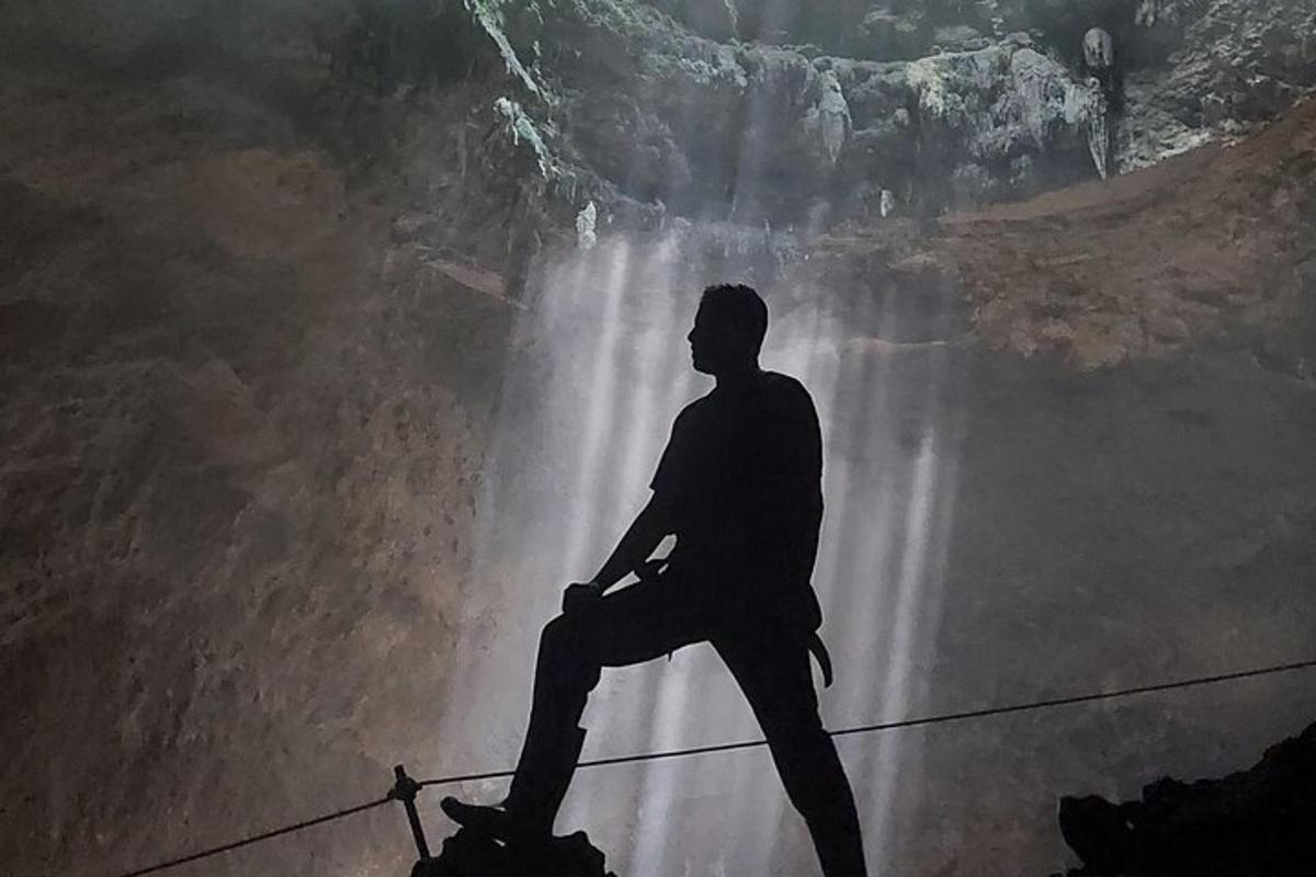 seorang lelaki duduk di atas wayar di hadapan air terjun