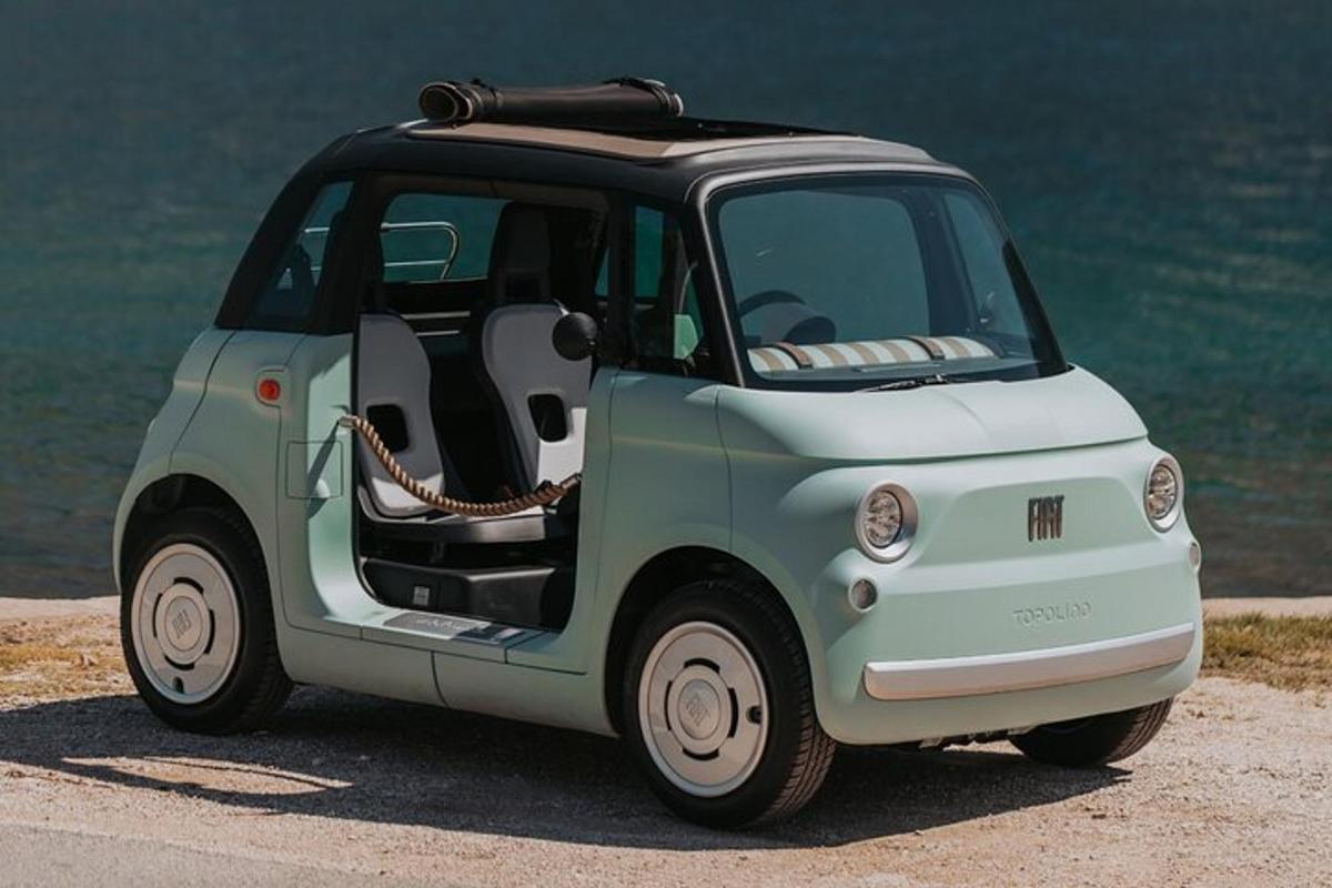 海のそばに駐車された緑と白の小さな車
