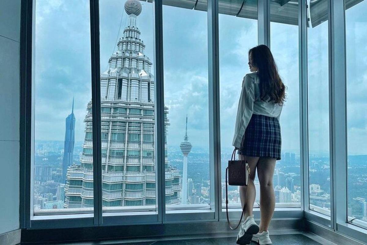 a woman standing in front of a window looking at the city