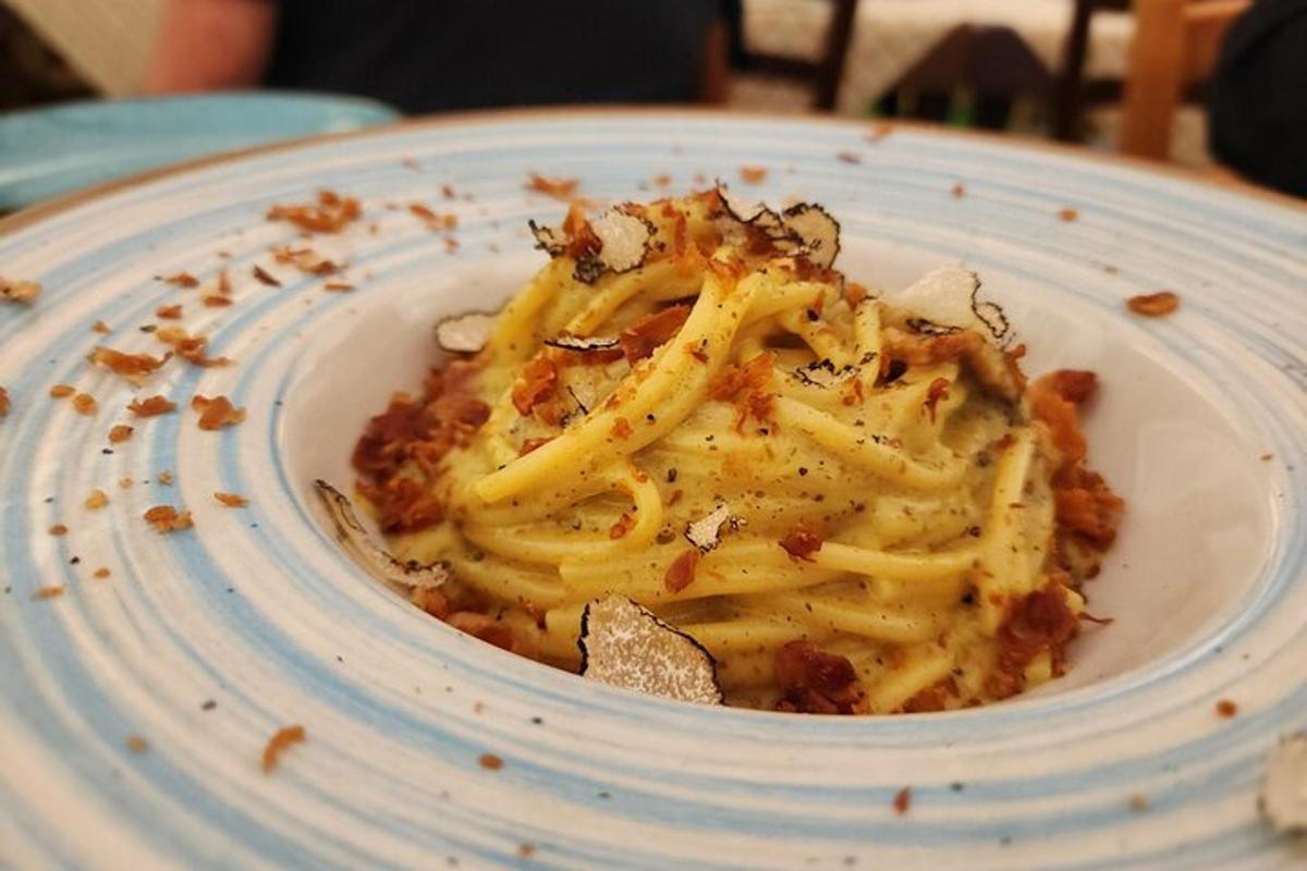 en tallerken pasta med ost på et bord