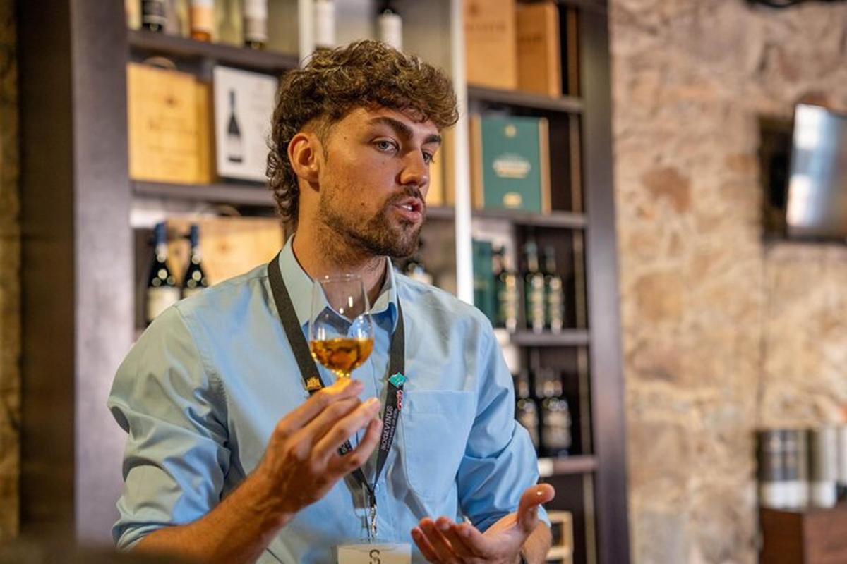 muškarac stoji u baru držeći čašu vina