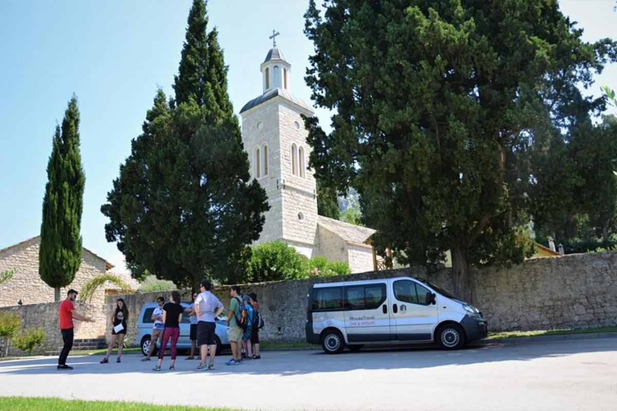 um grupo de pessoas em pé ao redor de uma van em frente a uma igreja