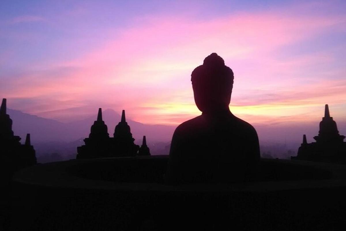 una silueta de una persona mirando la puesta de sol