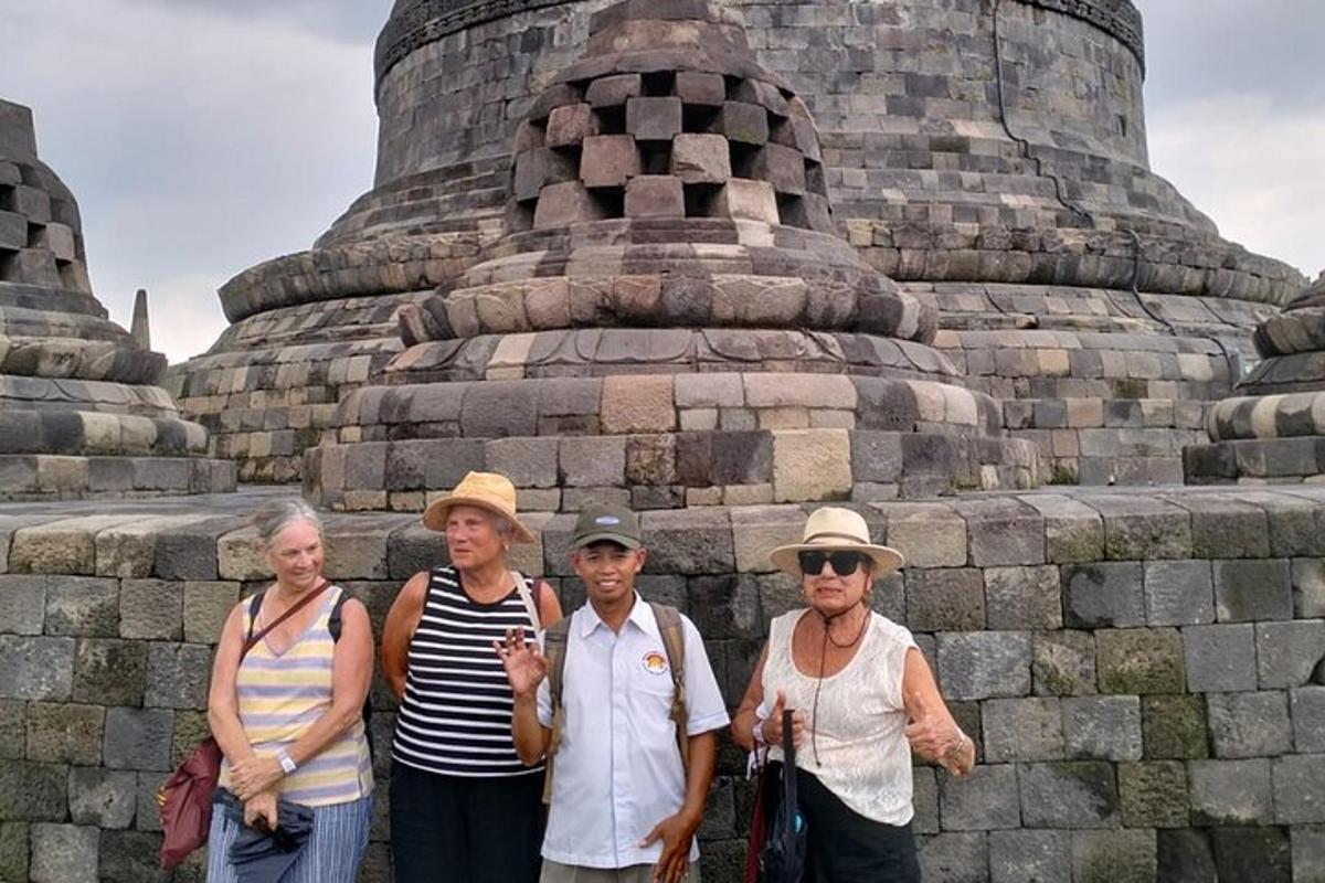 un grup de persones dretes davant d'un mur de pedra
