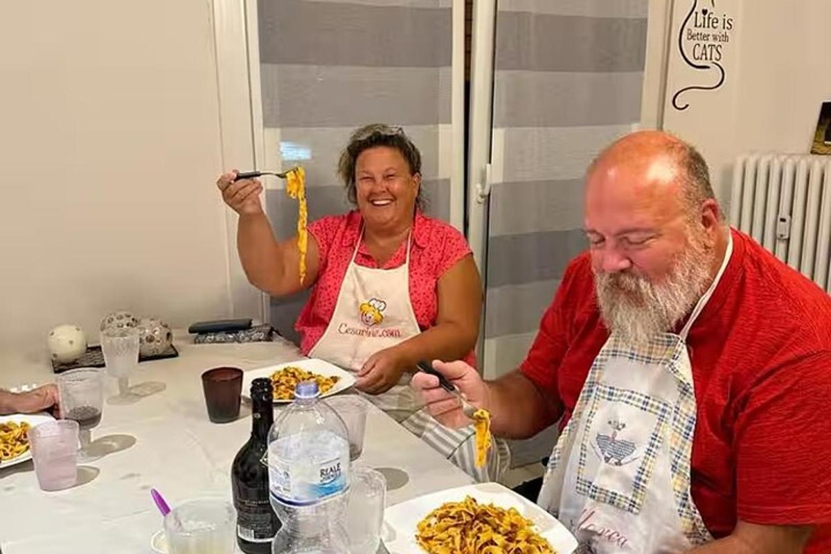 muž a žena sedí u stolu a jedí špagety