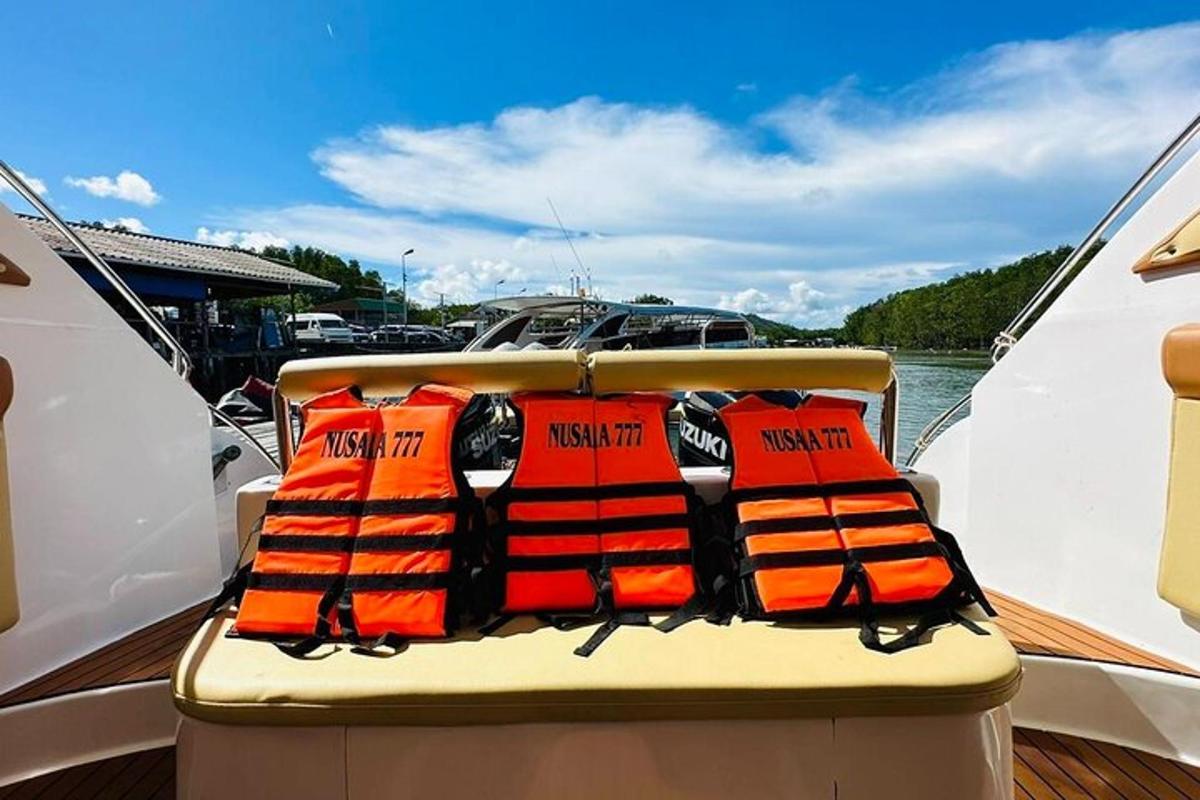 a boat with orange life jackets on the back of it