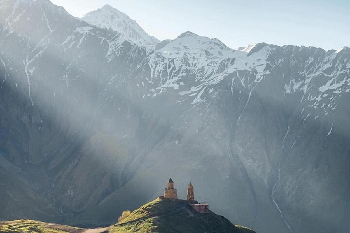 un edificio en la cima de una montaña con montañas nevadas