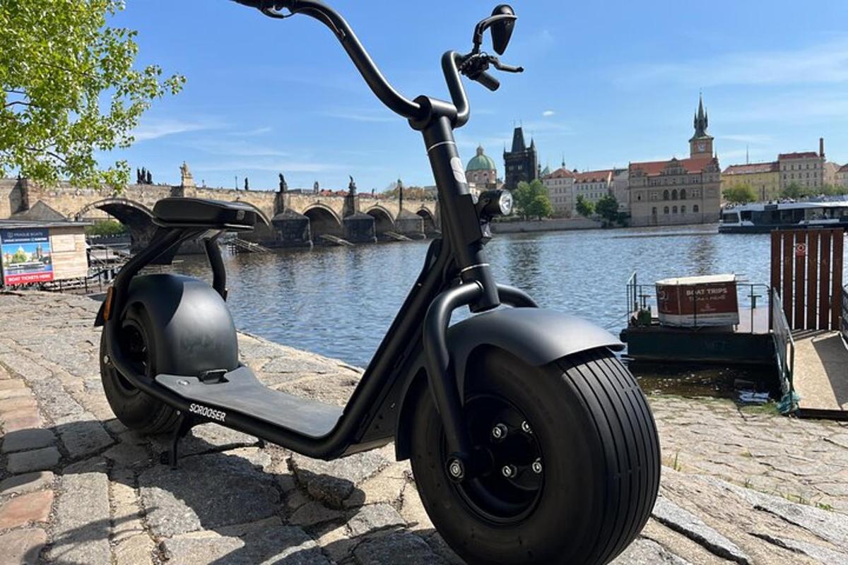egy folyó mellett parkoló motoros robogó