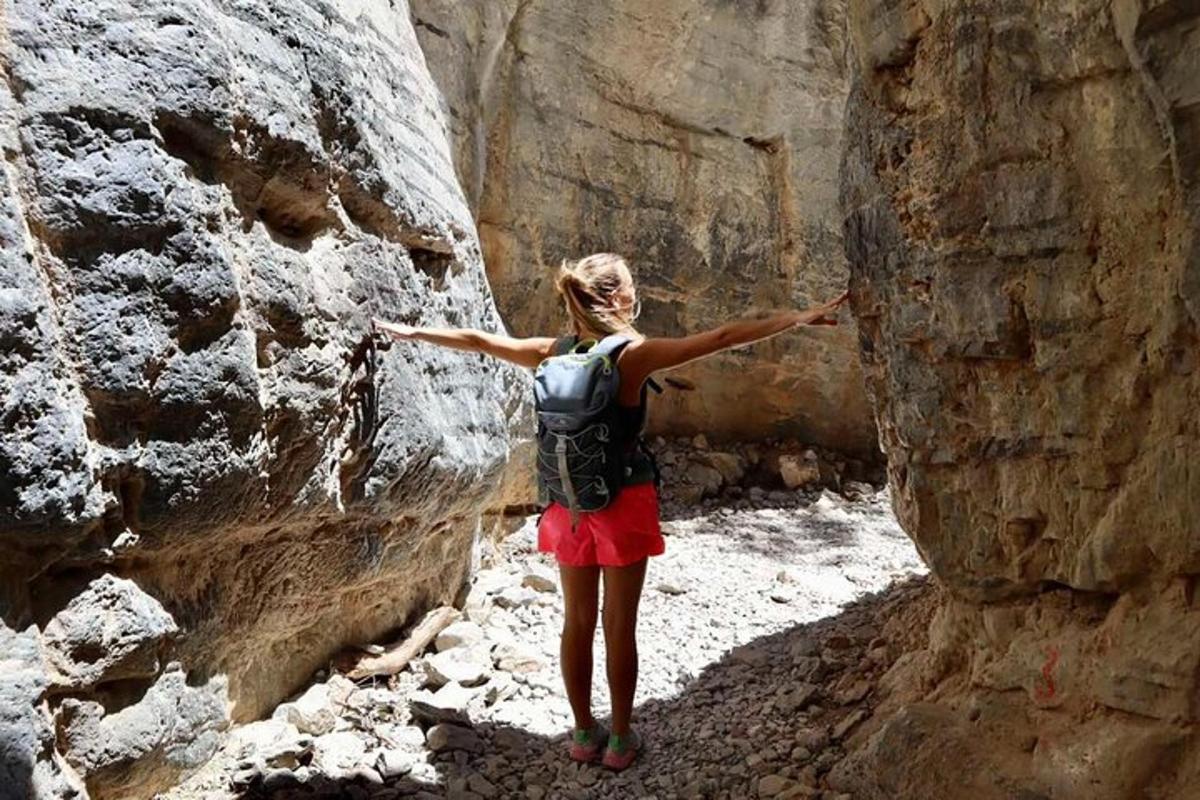 μια γυναίκα που στέκεται σε ένα φαράγγι με τα χέρια της απλωμένα