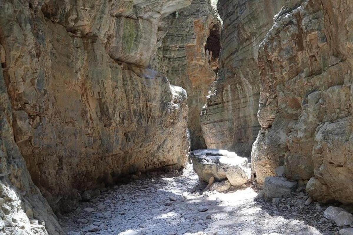 egy sziklás kanyon, közepén egy barlanggal