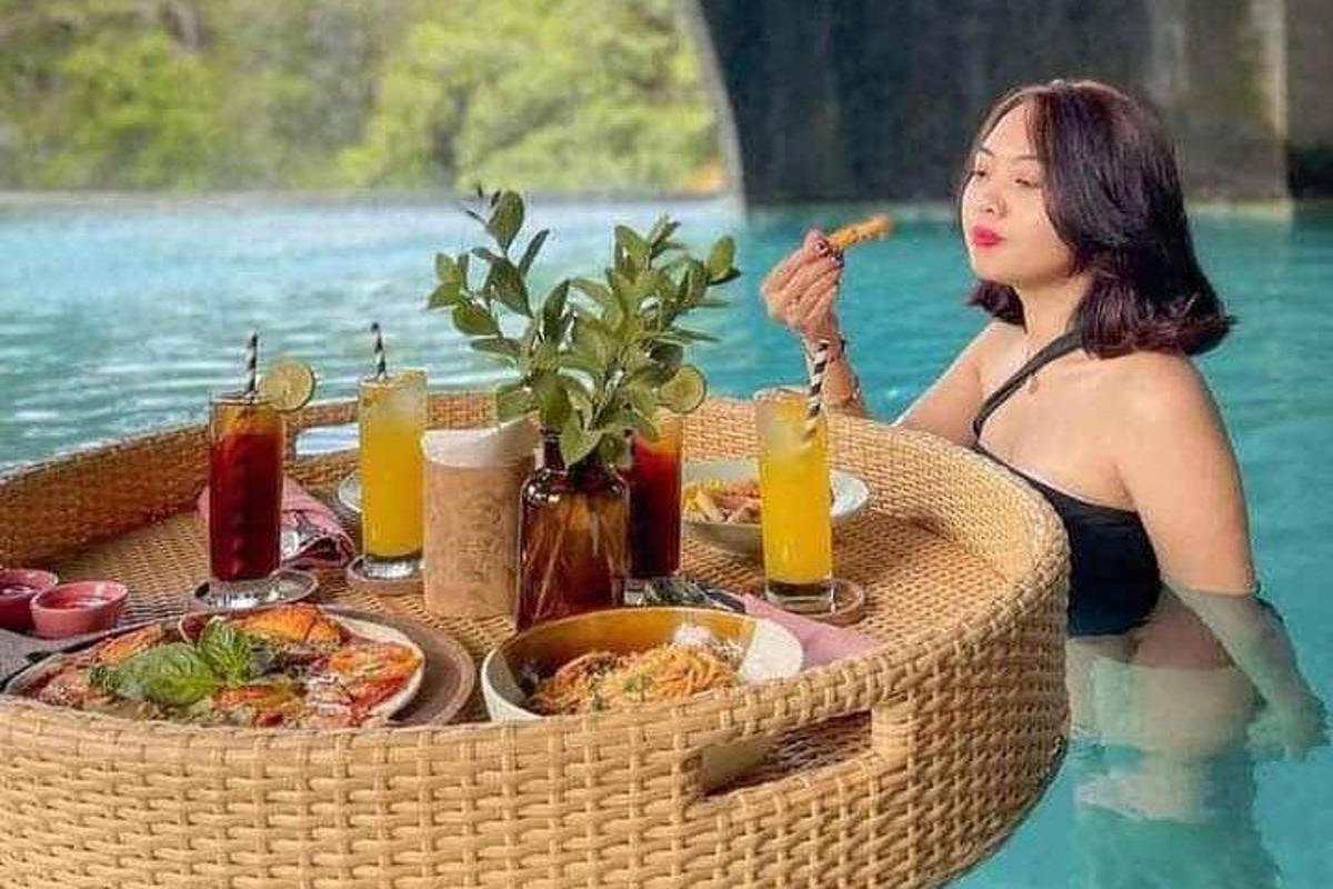 seorang wanita duduk di meja di dalam air makan makanan