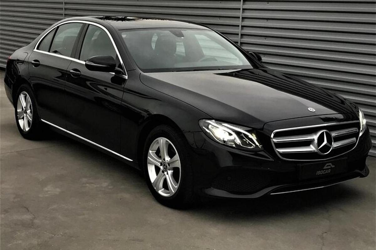 Un coche negro aparcado delante de un garaje.