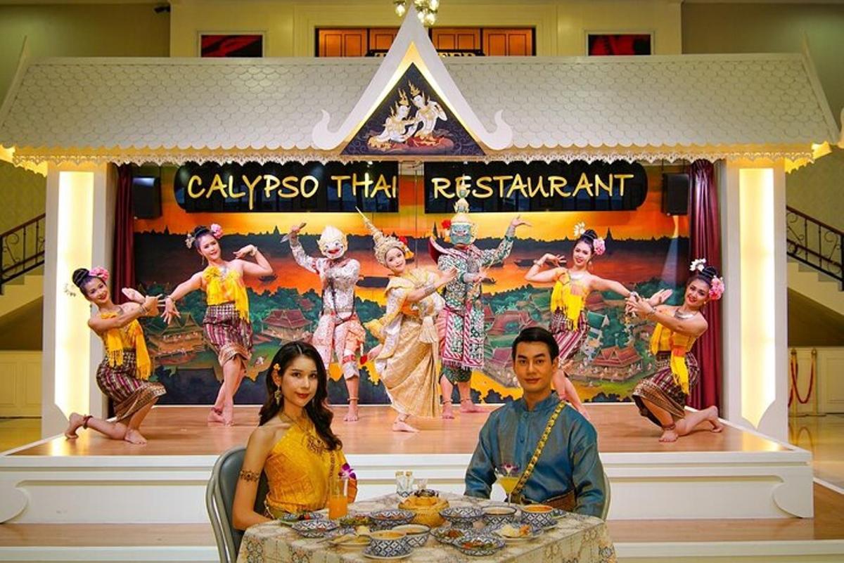 a man and woman sitting at a table in front of a performance